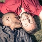 Dois homens deitados na relva, um com uma camisola vermelha a beijar a testa do outro com uma camisola cinzenta, desafiando de forma bela alguns dos maiores mitos sobre a homossexualidade.